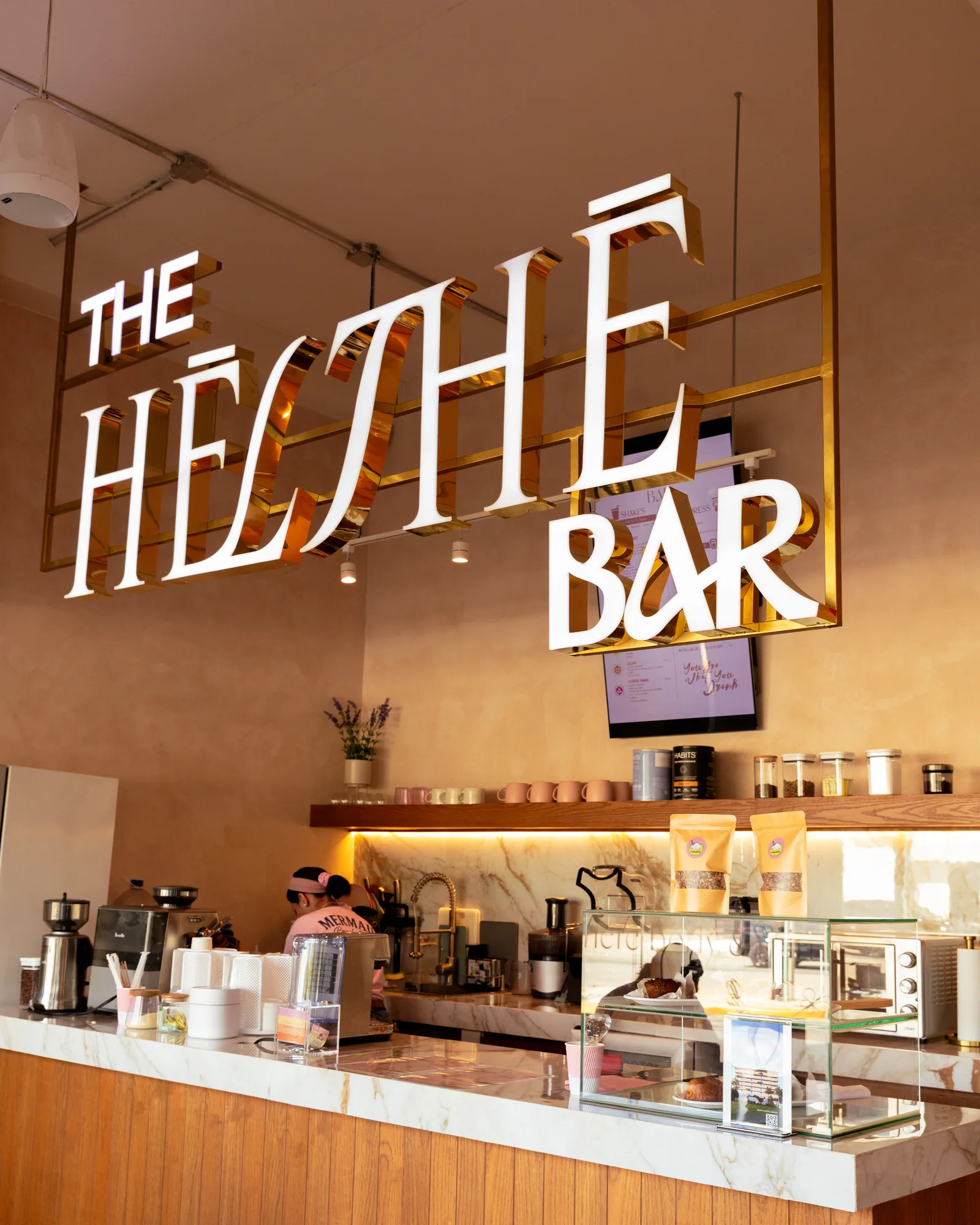Barra de The Hēlthē Bar con letrero dorado