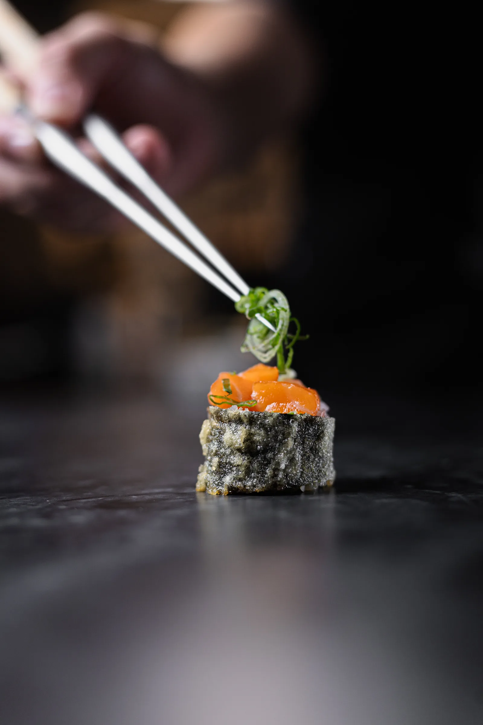 Salmon roll finished with tweezers, food photography in Cancún